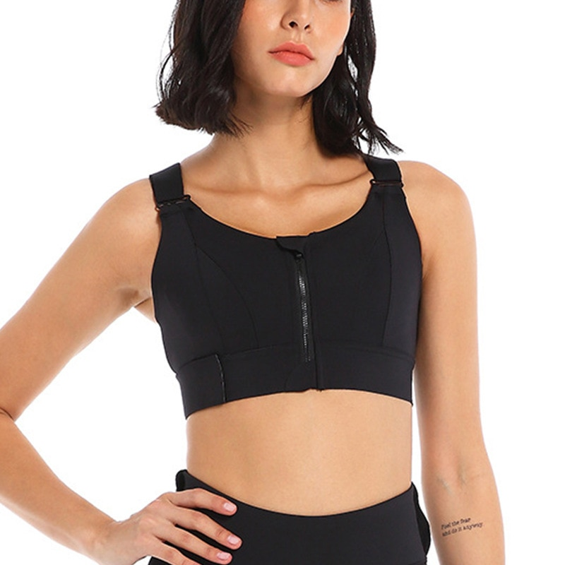 Girl wearing a black sports bra with front zip and velcro adjustable straps.
